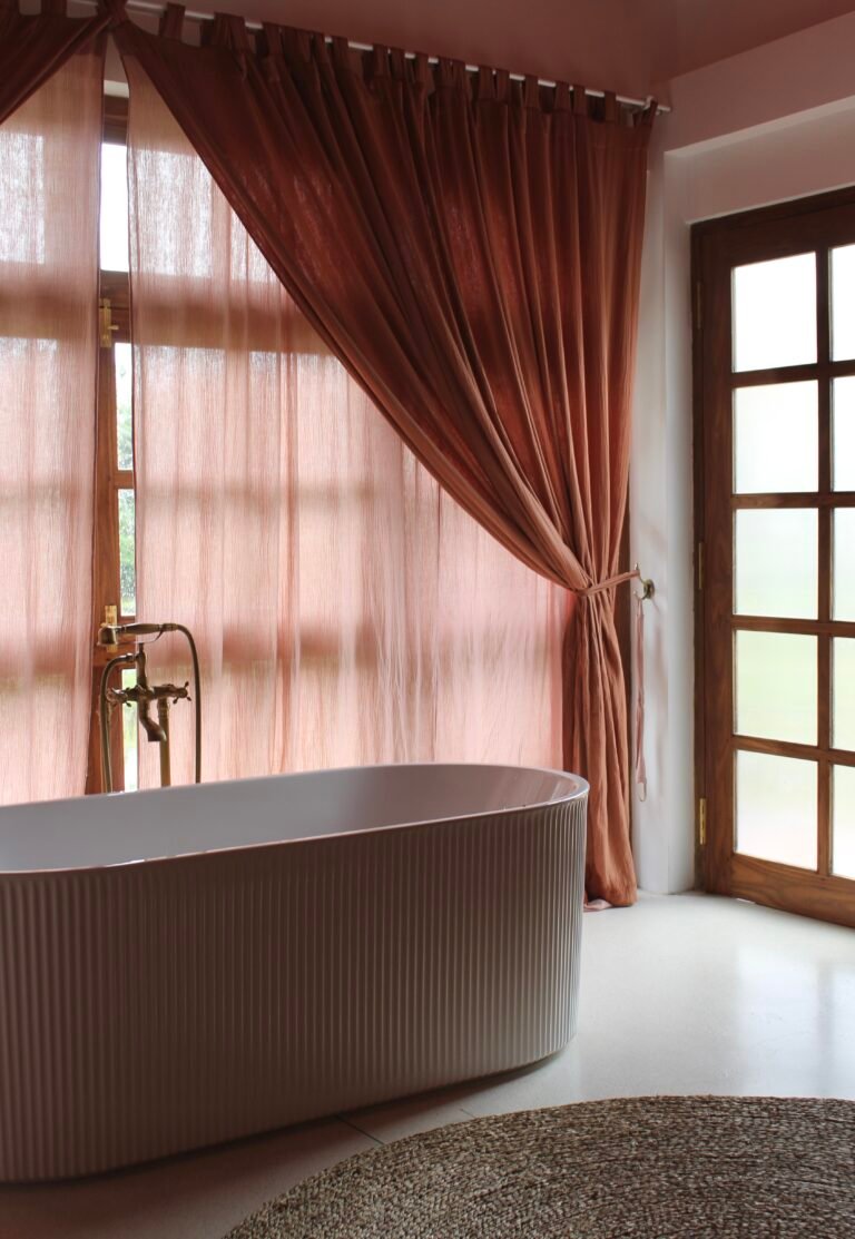Upper-floor suite with a freestanding bathtub and terracotta curtains