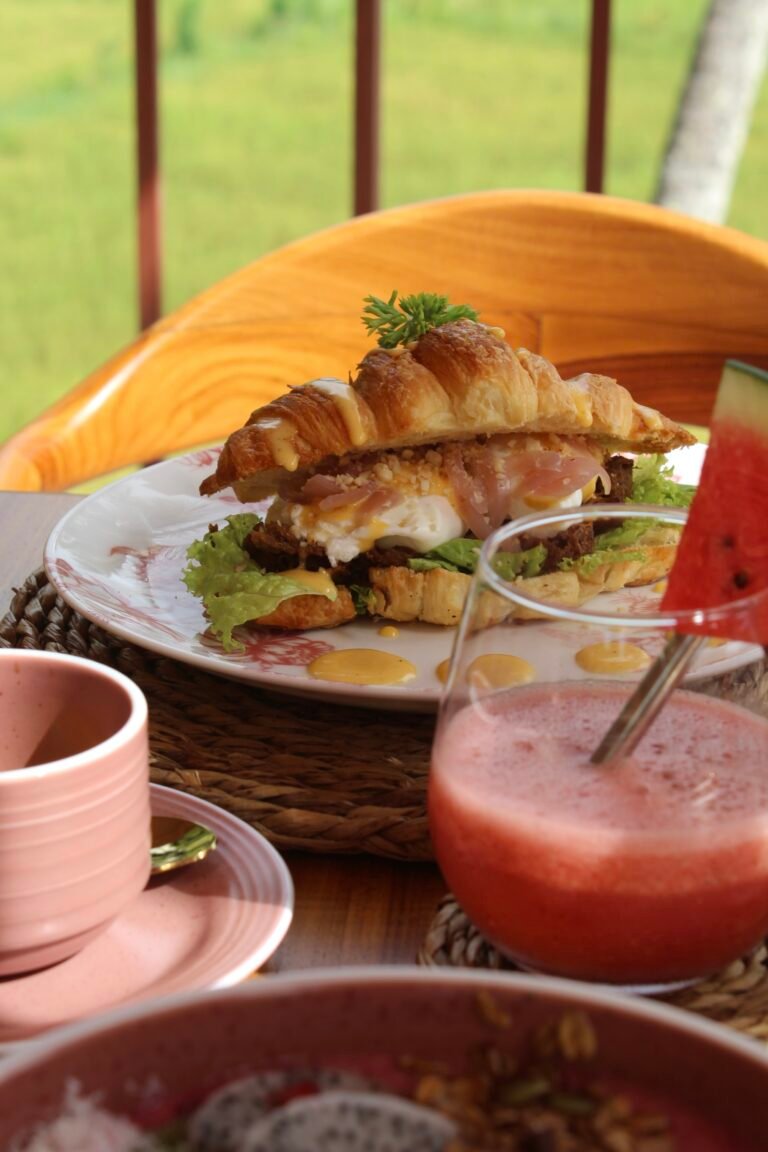 Breakfast with a croissant sandwich and fresh juice, facing the rice fields