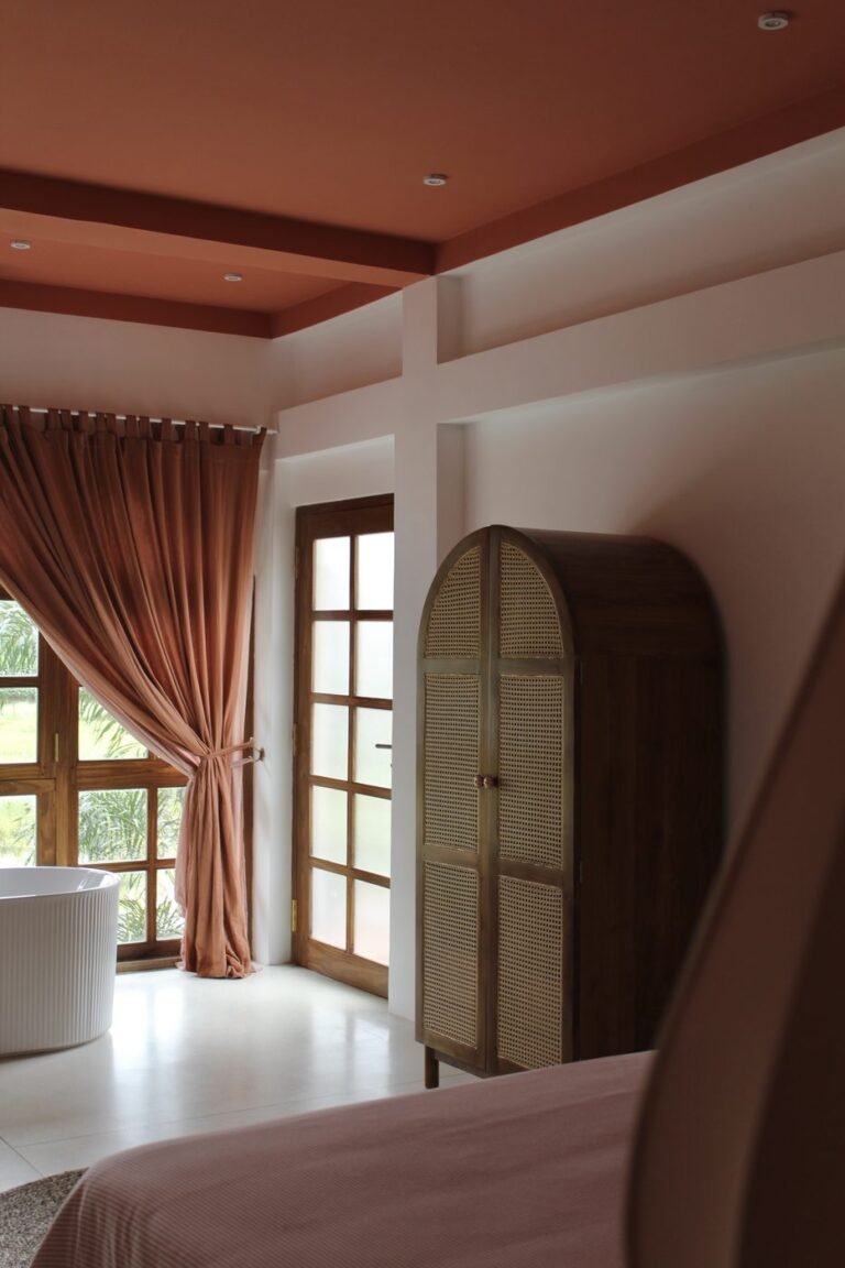 Suite interior with terracotta curtains and rattan wardrobe